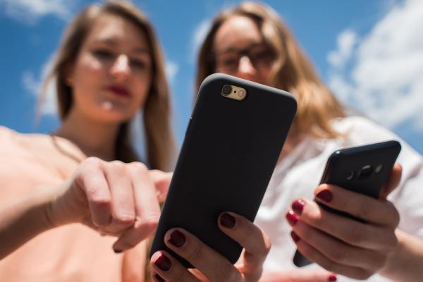 two women using smartphones